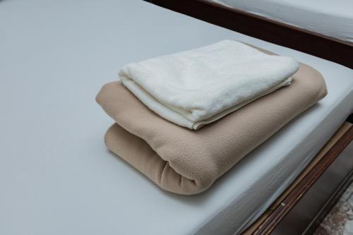 a stack of towels sitting on a bed at Mix Hotel in Ban Hua Thale