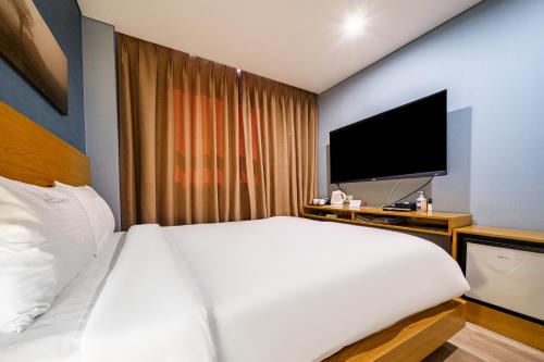 a hotel room with a bed and a television at Lamer Hotel in Busan