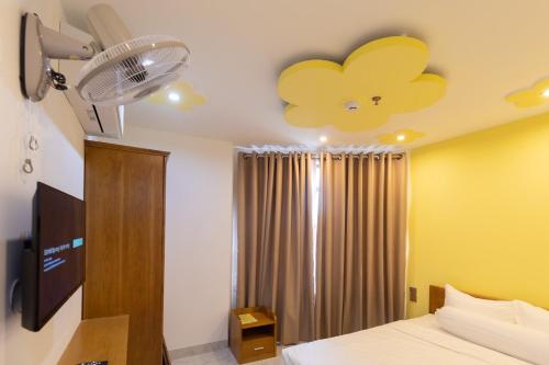 Schlafzimmer mit einem Bett mit Blumendecke in der Unterkunft 26 Topaz Hotel in Vũng Tàu