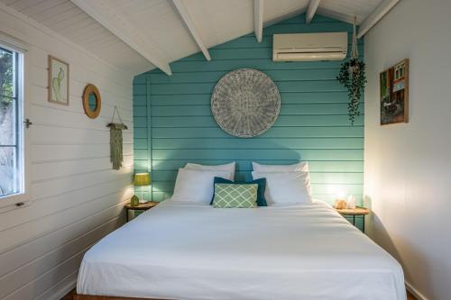 a bed in a room with a blue wall at OTRO Curaçao - Urban Oasis in Otrobanda in Willemstad