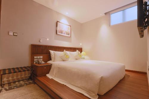 a bedroom with a large bed and a window at CHERRY BOUTIQUE HOTEL in Ho Chi Minh City
