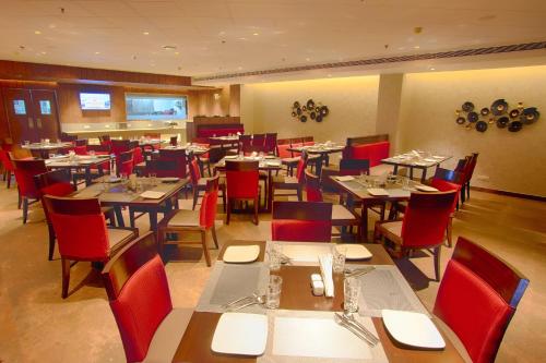 a dining room with tables and red chairs at Sunhill Portico in Siliguri