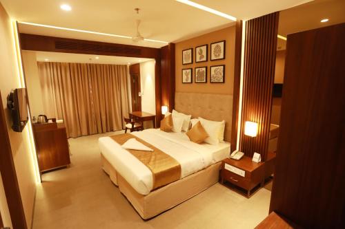 a bedroom with a large bed in a hotel room at Magnet Hotel in Kannur