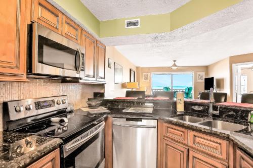 a kitchen with stainless steel appliances and wooden cabinets at Sand and Sea Enjoyment Retreat in Ormond Beach