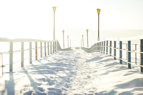 a boardwalk covered in snow next to a fence at Sanatoriy Elektra in Tal'tsy