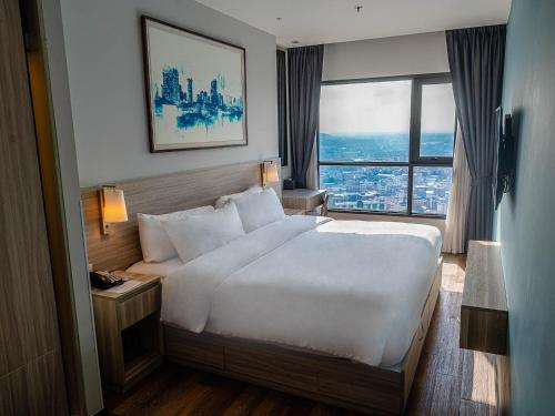a bedroom with a large white bed and a window at Oakwood Hotel & Residence Sri Racha in Si Racha