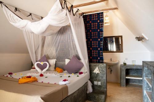 sypialnia z łóżkiem z moskitierą w obiekcie Nur Beach Hotel w mieście Jambiani