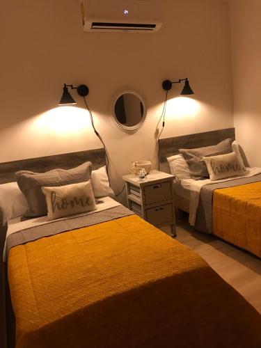 a bedroom with two beds and a table with a lamp at Garden Suites Comalcalco in Comalcalco
