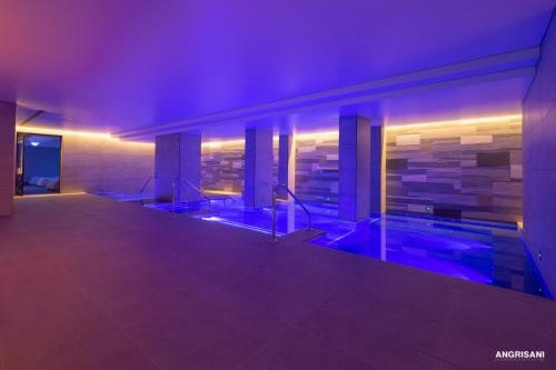 a swimming pool in a building with purple lights at San Severino Park Hotel & SPA, BW Signature Collection in Mercato San Severino