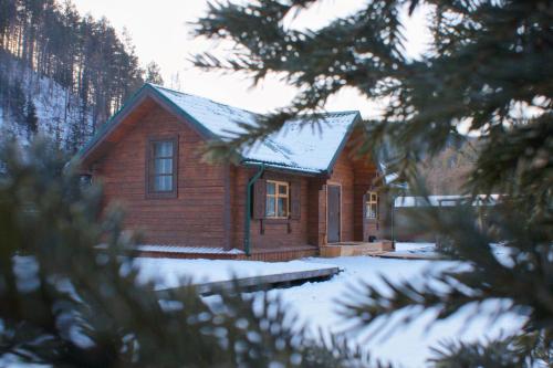 a small wooden house with snow on the roof at Eco Centre Talovskoe in Topilo