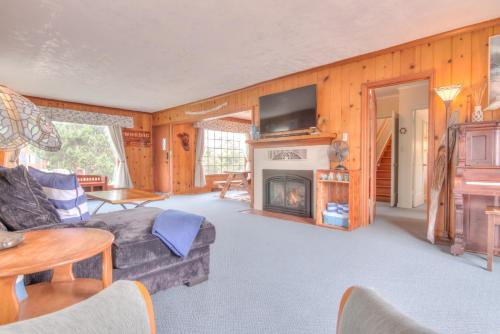 a living room with a couch and a fireplace at The Nordic House in the Cove - Meredith Lodging in Seaside