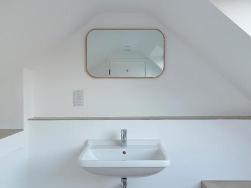 a bathroom with a sink and a mirror at High Cogges Farm Holiday Cottages - The Cart Shed in Witney