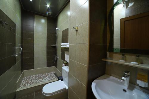 a bathroom with a toilet and a sink and a shower at Hotel Agava in Tbilisi City