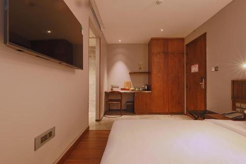 a bedroom with a bed with a television on the wall at CHERRY BOUTIQUE HOTEL in Ho Chi Minh City