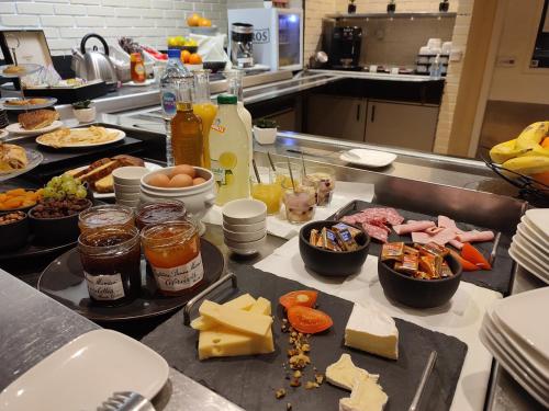 a kitchen with many plates of food on a counter at Hôtel Inn Design Resto Novo Bourges in Bourges