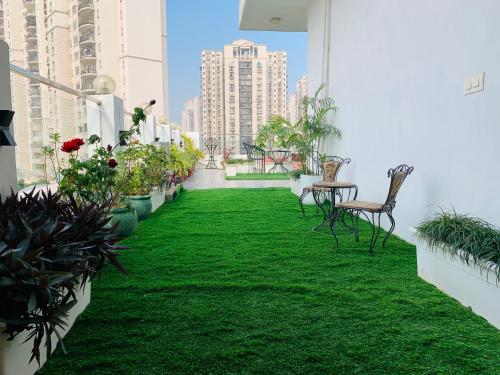 a balcony with green grass and chairs and plants at Hotel City Premier - Golf Course Road ,Gurgaon in Gurgaon