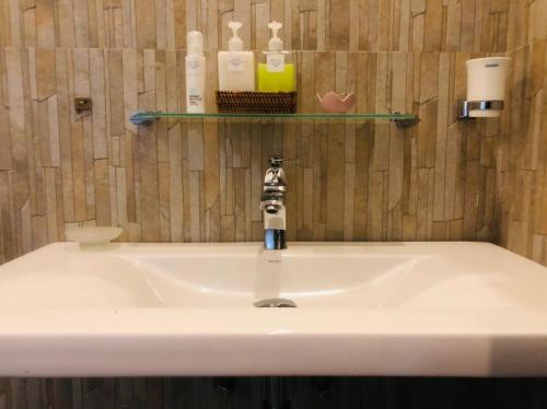 a white sink in a bathroom with a shelf at The Green Edge in Dambulla