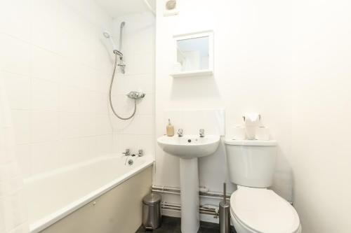 a white bathroom with a toilet and a sink at BEST PRICE!! - Contractor Heaven! 4 Singles beds or 2 King Size, Southsea Apartment- FREE PARKING, SMART TVS in Portsmouth