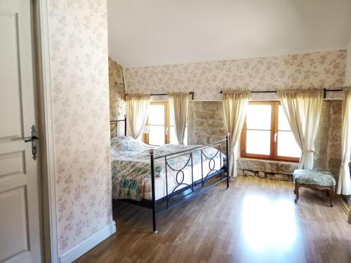une chambre avec un lit et deux fenêtres dans l'établissement Petit Chateau Melay, à Melay