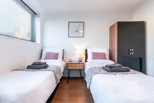 2 camas individuales en una habitación con ventana en BEST PRICE!! - Contractor Heaven! 4 Singles beds or 2 King Size, Southsea Apartment- FREE PARKING, SMART TVS en Portsmouth