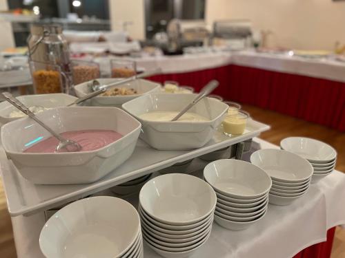 a buffet with white plates and bowls and dishes at Eden Hotel Früh am Dom in Cologne