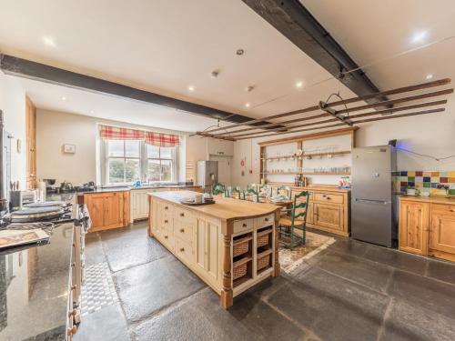 a large kitchen with wooden cabinets and stainless steel appliances at Abbey Farm House in St Bees