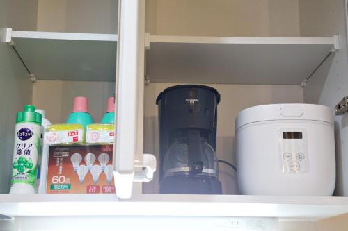 a cupboard with a coffee maker and other kitchen items at TOMMY CONDOMINIUM WAKASA 601 in Naha