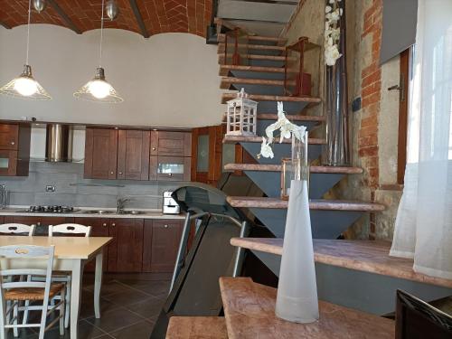 a kitchen with a spiral staircase and a table at La Limonaia Country House in Monteriggioni