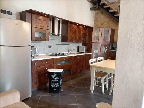 a kitchen with a white refrigerator and a table at La Limonaia Country House in Monteriggioni