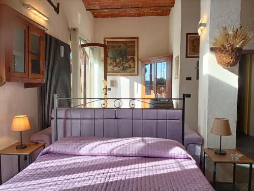sypialnia z fioletowym łóżkiem z 2 lampami w obiekcie La Limonaia Country House w mieście Monteriggioni