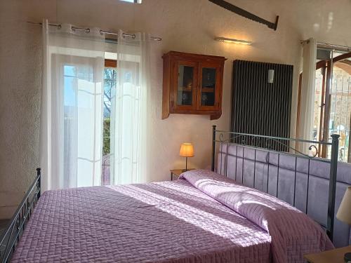 a bedroom with a bed with a purple bedspread at La Limonaia Country House in Monteriggioni