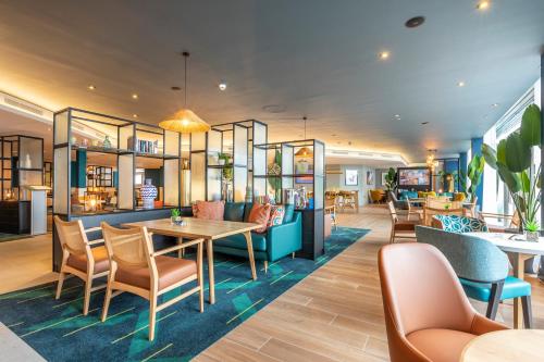 a restaurant with a table and chairs in a room at Holiday Inn Oxford by IHG in Oxford