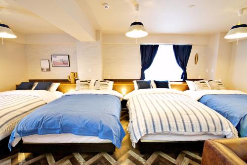 a room with four beds and a window at TOMMY CONDOMINIUM WAKASA 601 in Naha