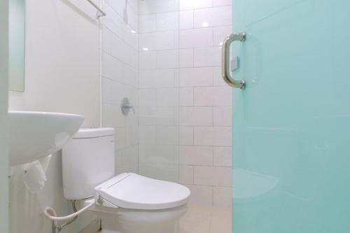 a bathroom with a toilet and a sink at LeGreen Suite Sudirman in Jakarta