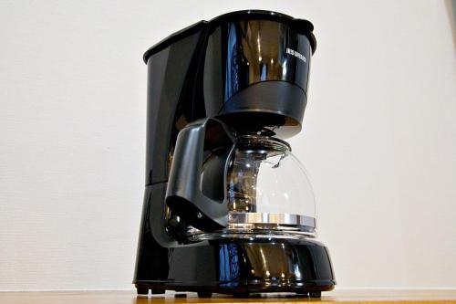 a black coffee maker sitting on top of a table at TOMMY CONDOMINIUM WAKASA 601 in Naha