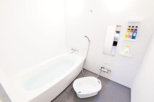 a white bathroom with a toilet and a sink at TOMMY CONDOMINIUM WAKASA 601 in Naha
