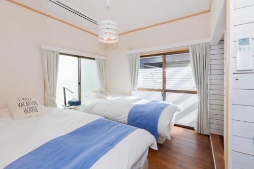 2 camas en una habitación con ventana en Blue Lagoon, en Kamakura