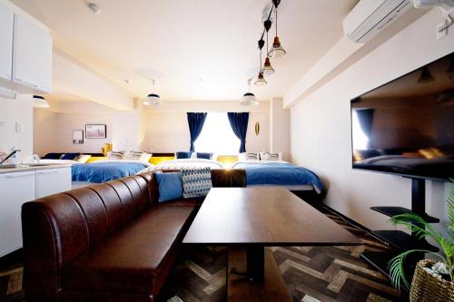 a living room with a couch and two beds at TOMMY CONDOMINIUM WAKASA 601 in Naha
