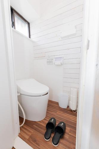 a bathroom with a toilet and a pair of slippers at Blue Lagoon in Kamakura