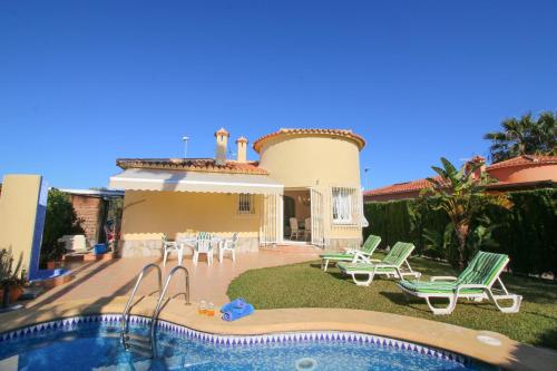 a villa with a swimming pool in front of a house at Oliva Nova QL by CARLOSFERIEN in Oliva