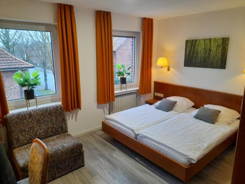 een slaapkamer met een bed, een stoel en een raam bij Hotel Zurmühlen in Sendenhorst