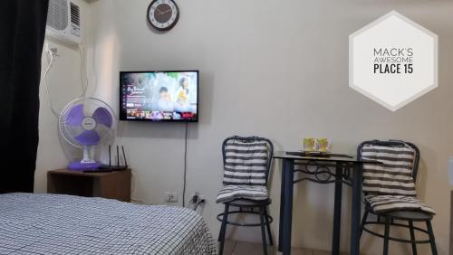 una camera da letto con due sgabelli e una TV a parete di Mack's Awesome 15 with Netflix and FastUnliwifi a Manila