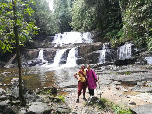 two women standing in front of a waterfall at Sinharaja Vini Villa in Deniyaya