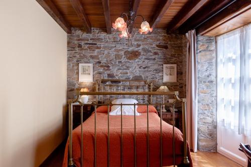 a bedroom with a bed and a brick wall at Casa Soto in Vegadeo