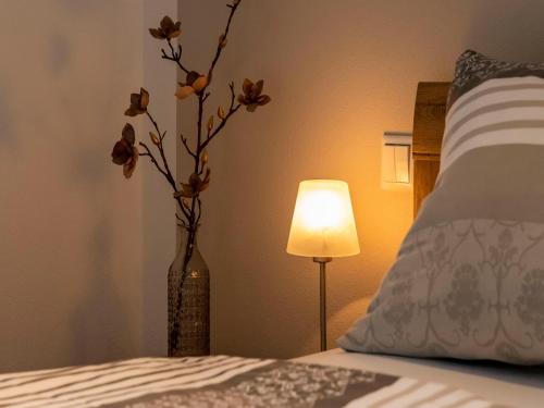 a vase with flowers in a room with a bed at Ferienwohnung Magnolie in Waging am See