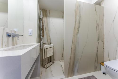 a white bathroom with a shower and a toilet at Apartamenty Żyła in Białka Tatrzańska