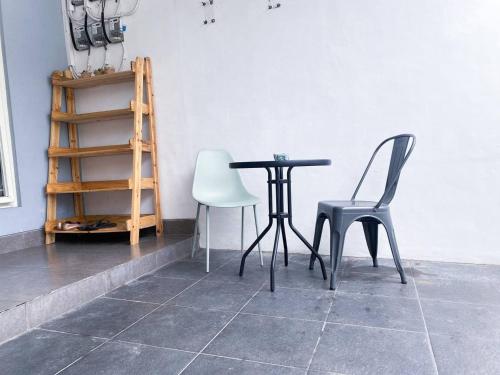 a table and two chairs in a room at Surabaya Homey near Juanda Airport Syariah in Sedati