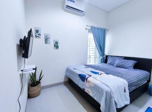 a bedroom with a bed and a television in it at Surabaya Homey near Juanda Airport Syariah in Sedati