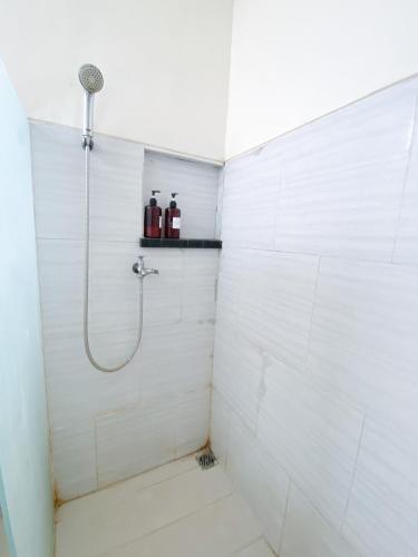 a bathroom with a shower with a shower head at Surabaya Homey near Juanda Airport Syariah in Sedati