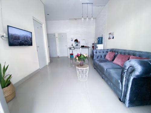 a living room with a blue couch and a table at Surabaya Homey near Juanda Airport Syariah in Sedati